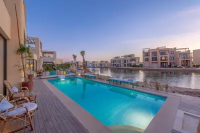 a swimming pool with a view of a river and buildings at La Casa de Playa Tawila on Island 4BR Private with Heated Pool in Hurghada