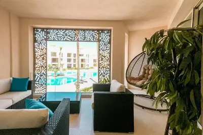 a living room with a view of a pool at Mangroovy 3BR Apartment Private Beach & Pool View in Hurghada