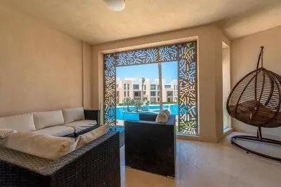 a living room with a couch and a large window at Mangroovy 3BR Apartment Private Beach & Pool View in Hurghada