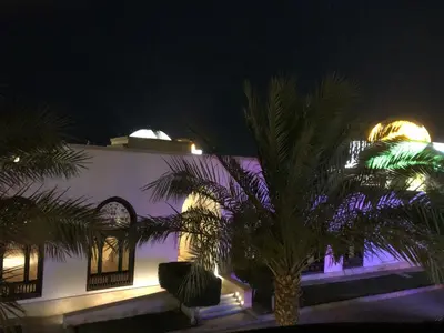 a building with palm trees in front of it at night at سهل حشيش in Hurghada