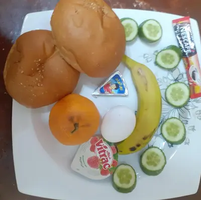 a plate of food with a hamburger and fruits and vegetables at Four Seasons Hotel in Hurghada