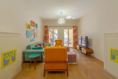 a living room with a couch and a tv at Marina Mosaique 1 BR Apartment with Pool view in Hurghada