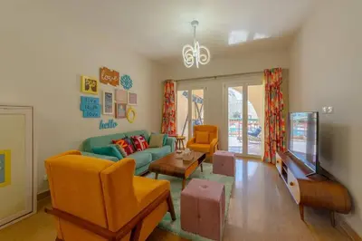 a living room with a couch and a tv at Marina Mosaique 1 BR Apartment with Pool view in Hurghada
