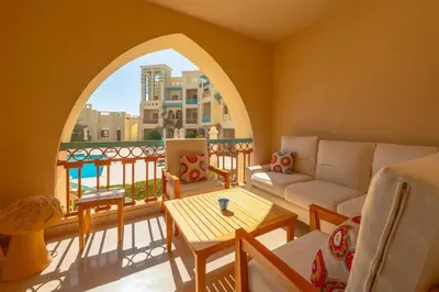 a living room with a couch and a table at Marina Mosaique 1 BR Apartment with Pool view in Hurghada