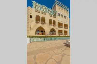 a building with a bench in front of it at Marina Mosaique 1 BR Apartment with Pool view in Hurghada