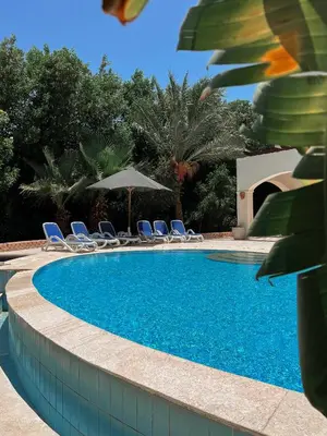 a swimming pool with chairs and umbrellas at GS 18 Villa in Hurghada