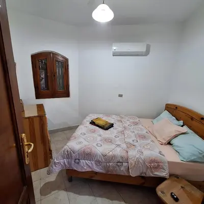 a bedroom with a bed with a book on it at Downtown ElGouna Excellent Location in Hurghada
