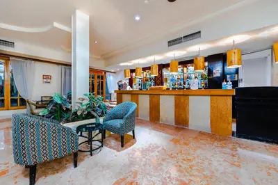 a lobby with two chairs and a bar at The Grand Hotel, Hurghada in Hurghada