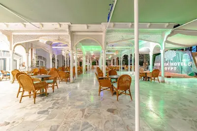 a dining area with tables and chairs in a building at The Grand Hotel, Hurghada in Hurghada