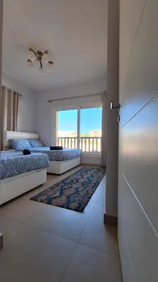 a bedroom with two beds and a large window at Waterside Apartments, El Gouna - 1Bd Ground Floor in El Gouna