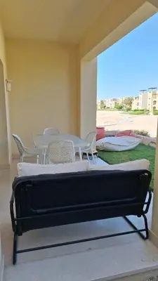 a bed in a room with chairs and a table at Waterside Apartments, El Gouna - 1Bd Ground Floor in El Gouna