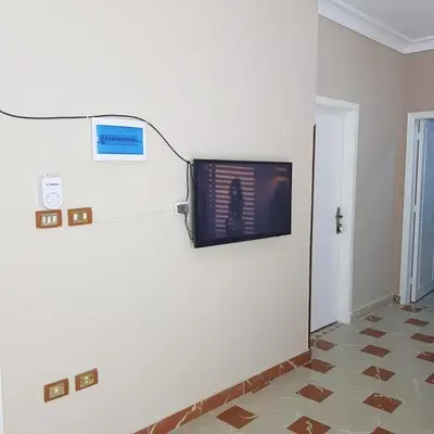 a room with a tv on a wall at Sweet Home Hostel- ممنوع للمصريين open 24 hour in Hurghada
