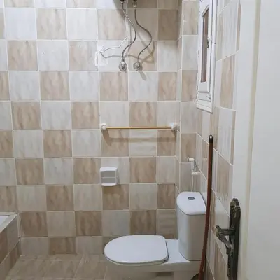 a small bathroom with a toilet and a shower at Sweet Home Hostel- ممنوع للمصريين open 24 hour in Hurghada