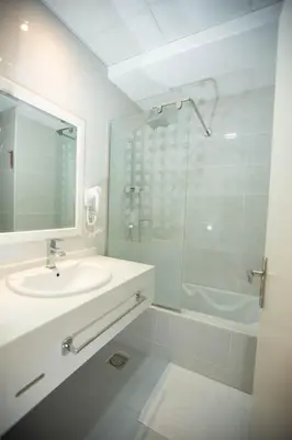 a bathroom with a sink and a glass shower at Gloria Aqua Park Hotel in Aswan
