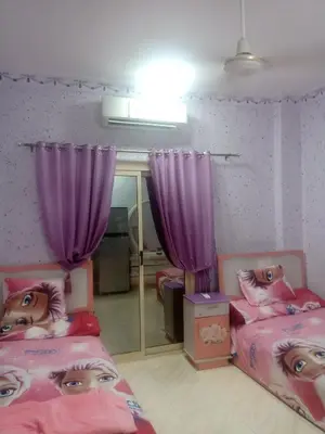 two beds in a room with purple curtains at App12 - RAWDA - Enjoy the privacy of staying in a quiet apartment with free Wi-Fi as your complete second home in the heart of Hurghada in Hurghada