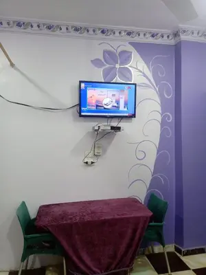 a room with a table and a tv on a wall at App12 - RAWDA - Enjoy the privacy of staying in a quiet apartment with free Wi-Fi as your complete second home in the heart of Hurghada in Hurghada