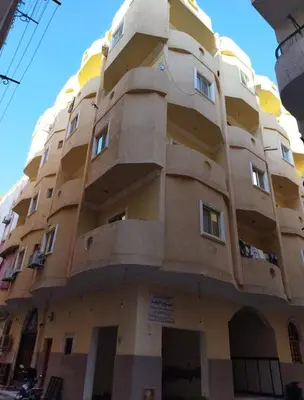 a large yellow building with windows on the side of it at App12 - RAWDA - Enjoy the privacy of staying in a quiet apartment with free Wi-Fi as your complete second home in the heart of Hurghada in Hurghada