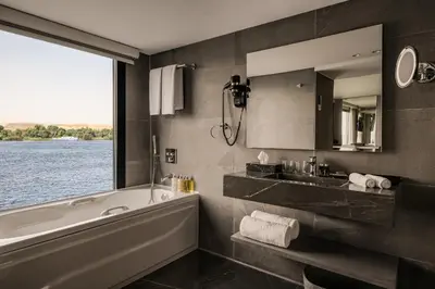 a bathroom with a tub and a large window at Historia The Boutique Hotel Nile Cruise - Every Monday from Luxor for 04 & 07 Nights - Every Friday From Aswan for 03 & 07 Nights in Luxor