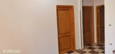 a hallway with wooden doors and a checkerboard floor at Tut flat in Luxor