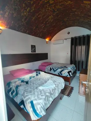 two beds in a room with a room with two beds at Jamaica Guest House in Aswan