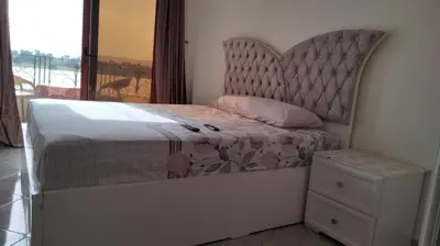 a bedroom with a bed with a large headboard at Nile queen Apartments for Rent in Luxor