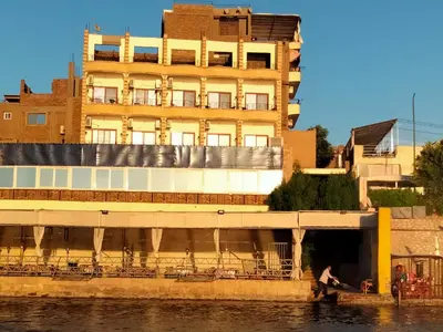 a building on the side of a river with a building at Nile queen Apartments for Rent in Luxor