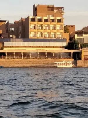 a large building on the shore of a body of water at Nile queen Apartments for Rent in Luxor