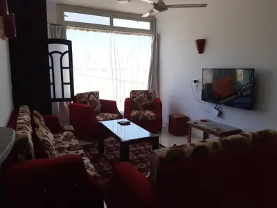 a living room with a couch and a table and a tv at German Dolphin in Quseir