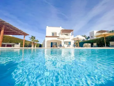 a large swimming pool in front of a villa at Luxury 4 bedroom villa with a heated pool in Hurghada