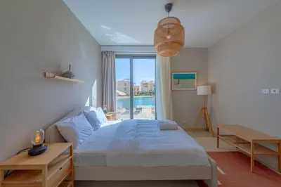 a bedroom with a bed and a large window at Long Island Gouna 5BR Tawila Beach House & Pool in Hurghada