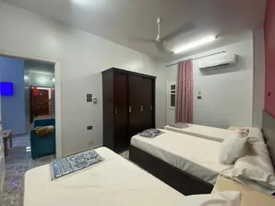 a hotel room with two beds and a mirror at ALRahman Building in Aswan