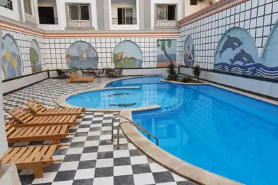 a large swimming pool with two chairs and a tile wall at sheraton blaza 101 in Hurghada