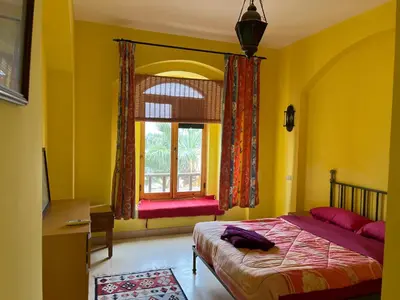 a bedroom with yellow walls and a bed and a window at El Gouna, Red Sea, Egypt, West Golf 2 Bedroom Flat in Hurghada