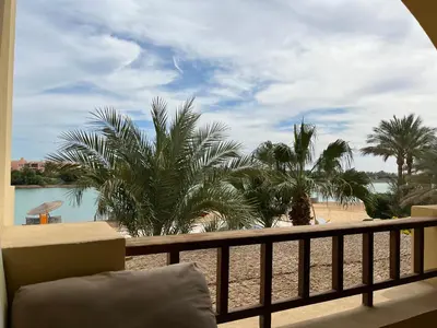 a balcony with a view of the beach and palm trees at El Gouna, Red Sea, Egypt, West Golf 2 Bedroom Flat in Hurghada
