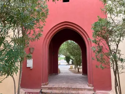 an entrance to a red building with an archway at El Gouna, Red Sea, Egypt, West Golf 2 Bedroom Flat in Hurghada