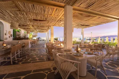 a restaurant with tables and chairs and a view of the city at Sunrise Tucana Resort Grand Select in Hurghada