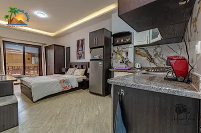 a kitchen and a bedroom with a bed in a room at Turtles Beach Resort Hurghada By VTGooo in Hurghada