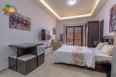 a bedroom with a bed and a desk in it at Turtles Beach Resort Hurghada By VTGooo in Hurghada