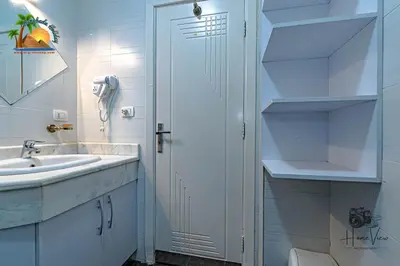 a white bathroom with a sink and a shower at Turtles Beach Resort Hurghada By VTGooo in Hurghada