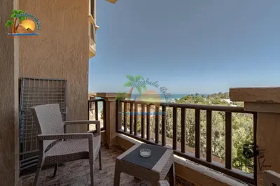 a balcony with two chairs and a table at Turtles Beach Resort Hurghada By VTGooo in Hurghada