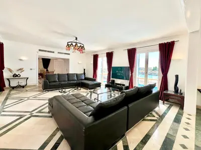 a living room with black leather furniture and red curtains at Hill Villa Venezia El Gouna: pool, beach & WiFi in Hurghada