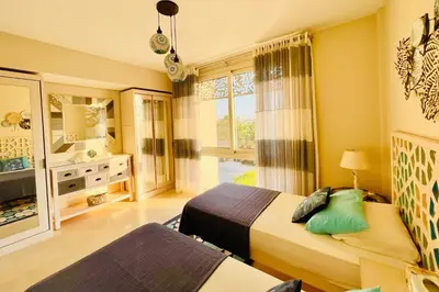 a hotel room with two beds and a bathroom at Kitesurfer Shared House, Pool View & Beach Access in Hurghada