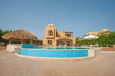 a large swimming pool with a house in the background at Y 140 wast golf heated private pool in Hurghada