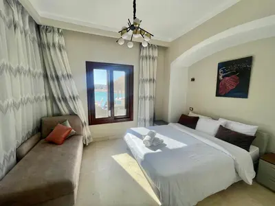 a bedroom with a large bed and a couch at Y 140 wast golf heated private pool in Hurghada