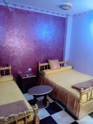 a room with two beds and a table in it at App11- BELAL - Enjoy the privacy of staying in a quiet apartment with free Wi-Fi as your complete second home in the heart of Hurghada in Hurghada