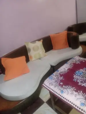 a couch with pillows on it next to a table at App11- BELAL - Enjoy the privacy of staying in a quiet apartment with free Wi-Fi as your complete second home in the heart of Hurghada in Hurghada