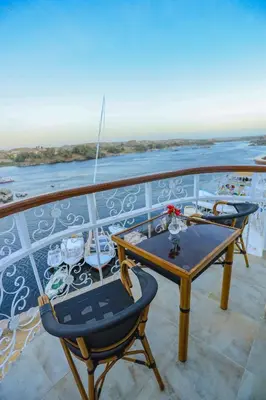 a table and a chair on the balcony of a boat at NUB INN in Aswan