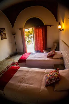 a bedroom with three beds and a window at NUB INN in Aswan