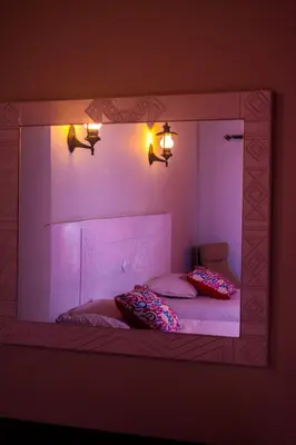 a mirror reflecting a bed with two pillows on it at NUB INN in Aswan