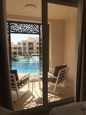 a view of a patio with two chairs and a table at Jutta Deluxe 2,5-Bedroom-Apartment Mangroovy-M10 El Gouna in Hurghada